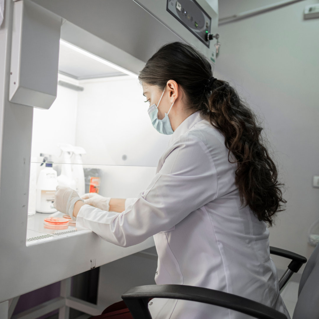 Female scientist in white lab coat and face mask working under laboratory fume hood representing Smart Caffeine science-backed formulation